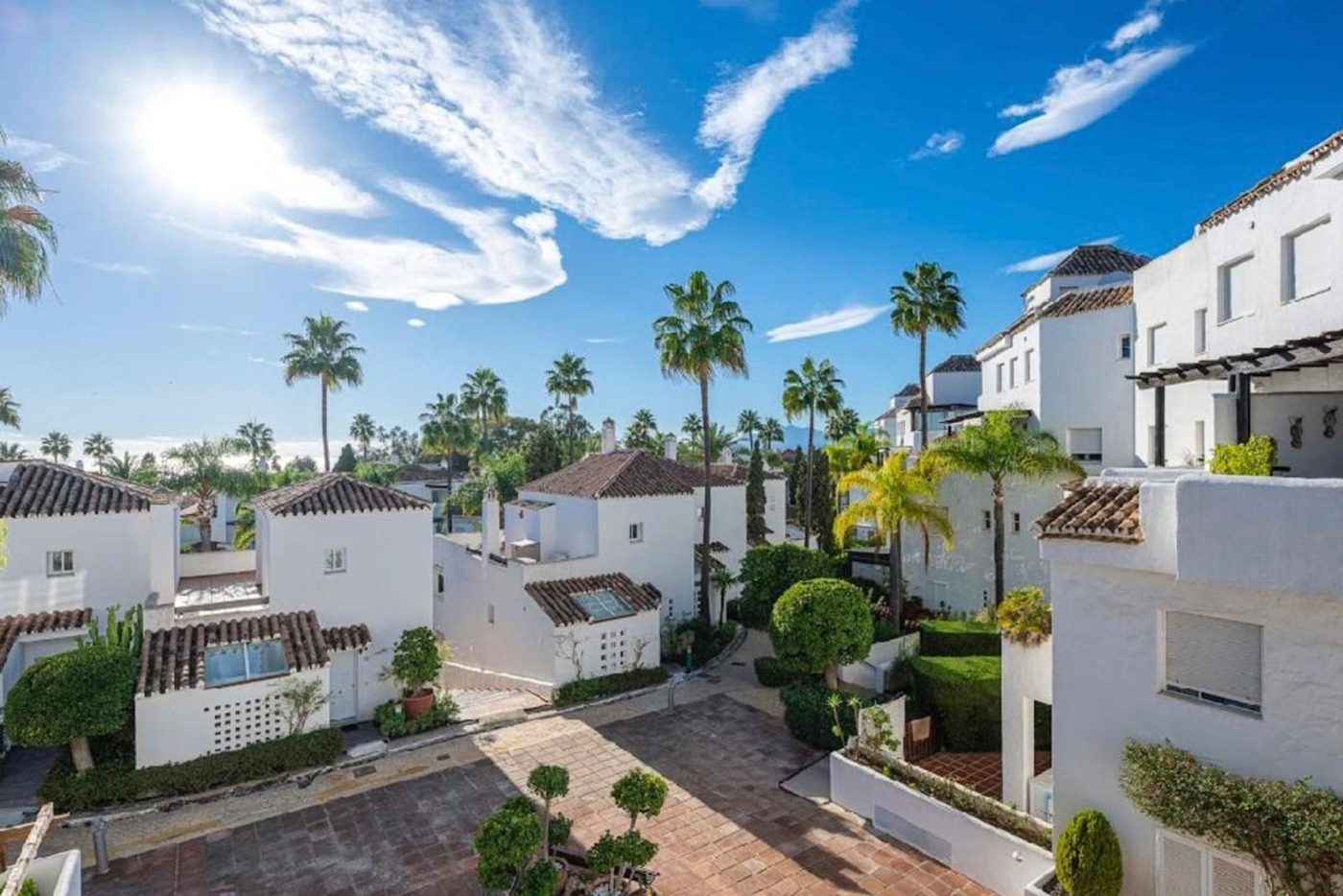 Low built white houses and palms in Bahía de Marbella