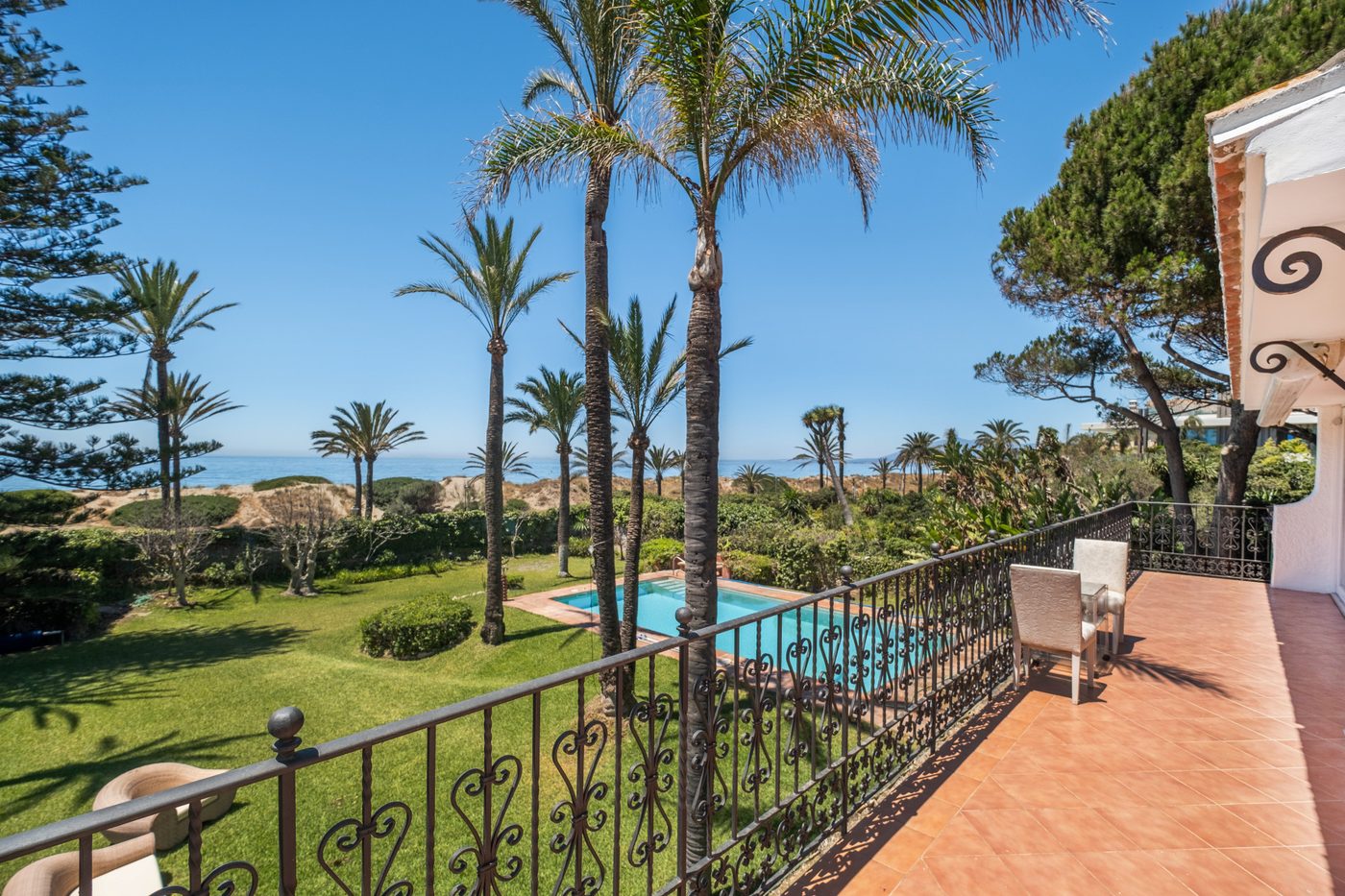 A garden and pool on the Bahía de Marbella front row, looking over the dune to the sea