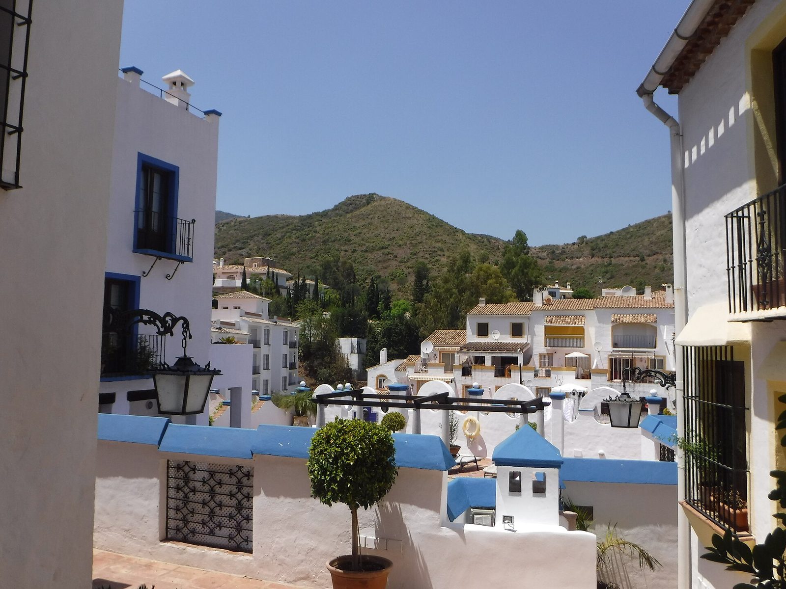 Whitewashed street in Benahavís village with the hills behind