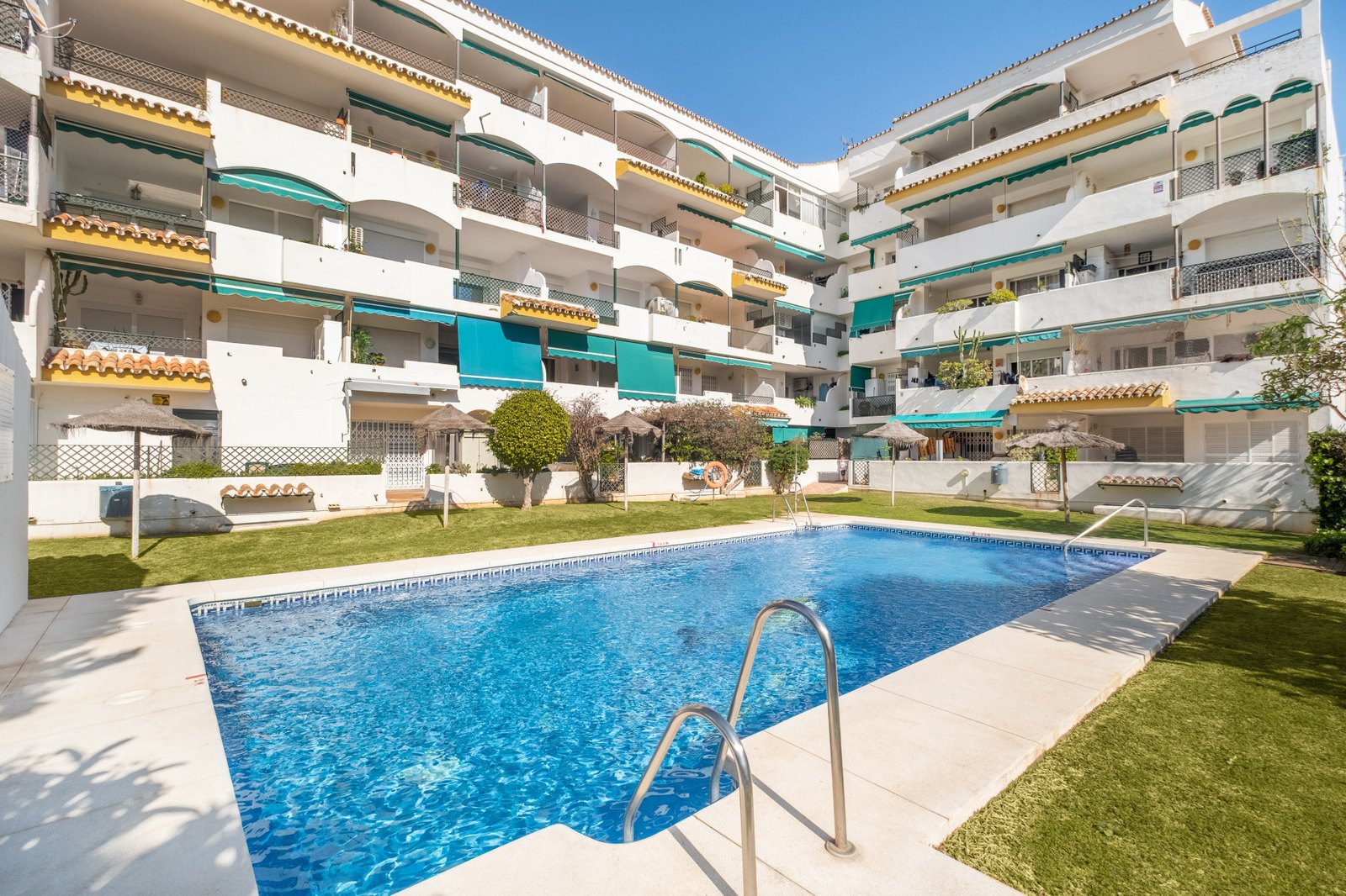 A shared pool and garden in a community at Cabopino, Marbella