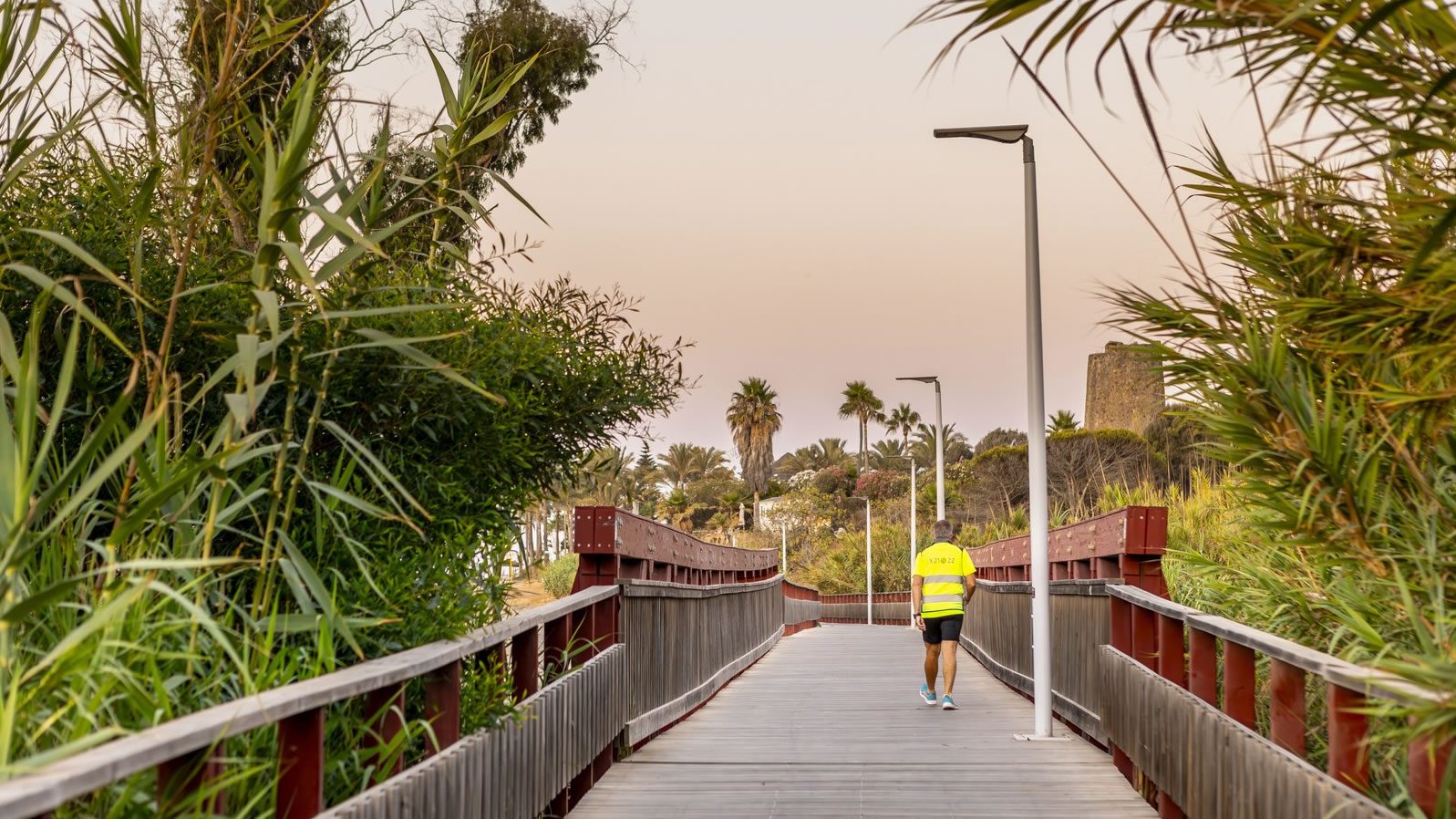 Walker crossing one of the timber footbridges on the Estepona Corredor Litoral