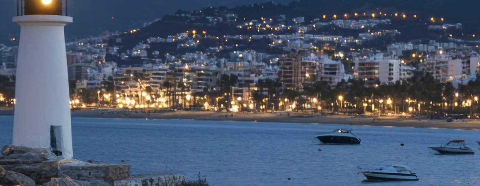 Marbella bay at dusk seen past the lighthouse