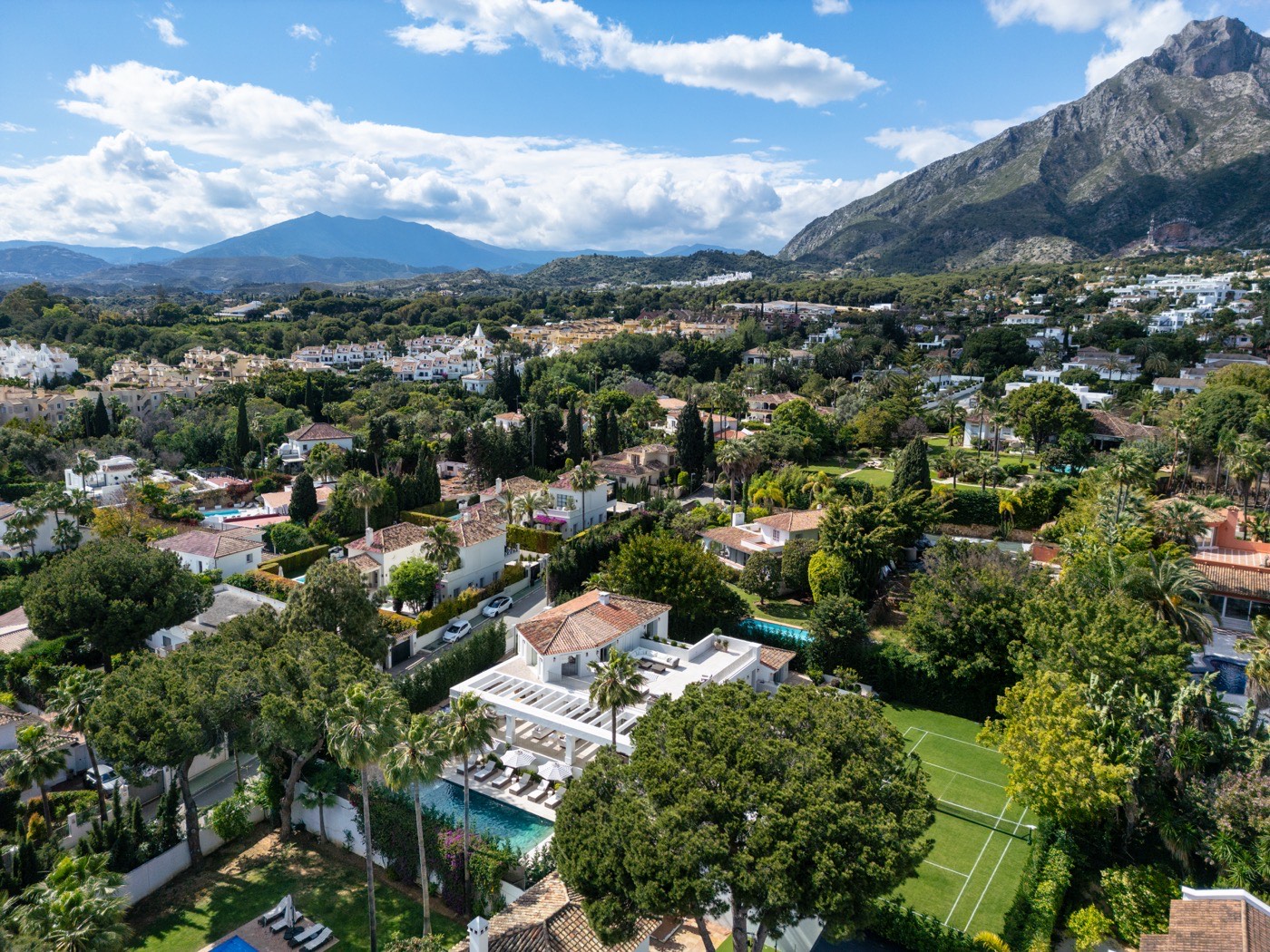 Prime Real Estate in Marbella: aerial view over a residential urbanisation with La Concha and the Sierra Blanca ridge behind