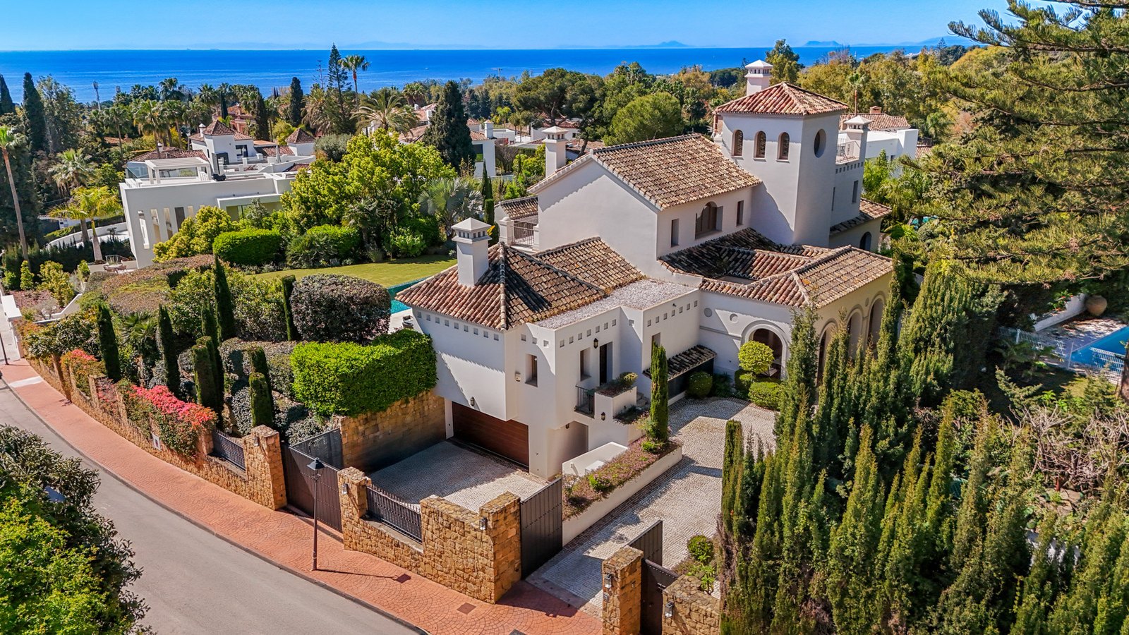 A walled villa on one of the lanes of La Carolina, Marbella, with the bay beyond