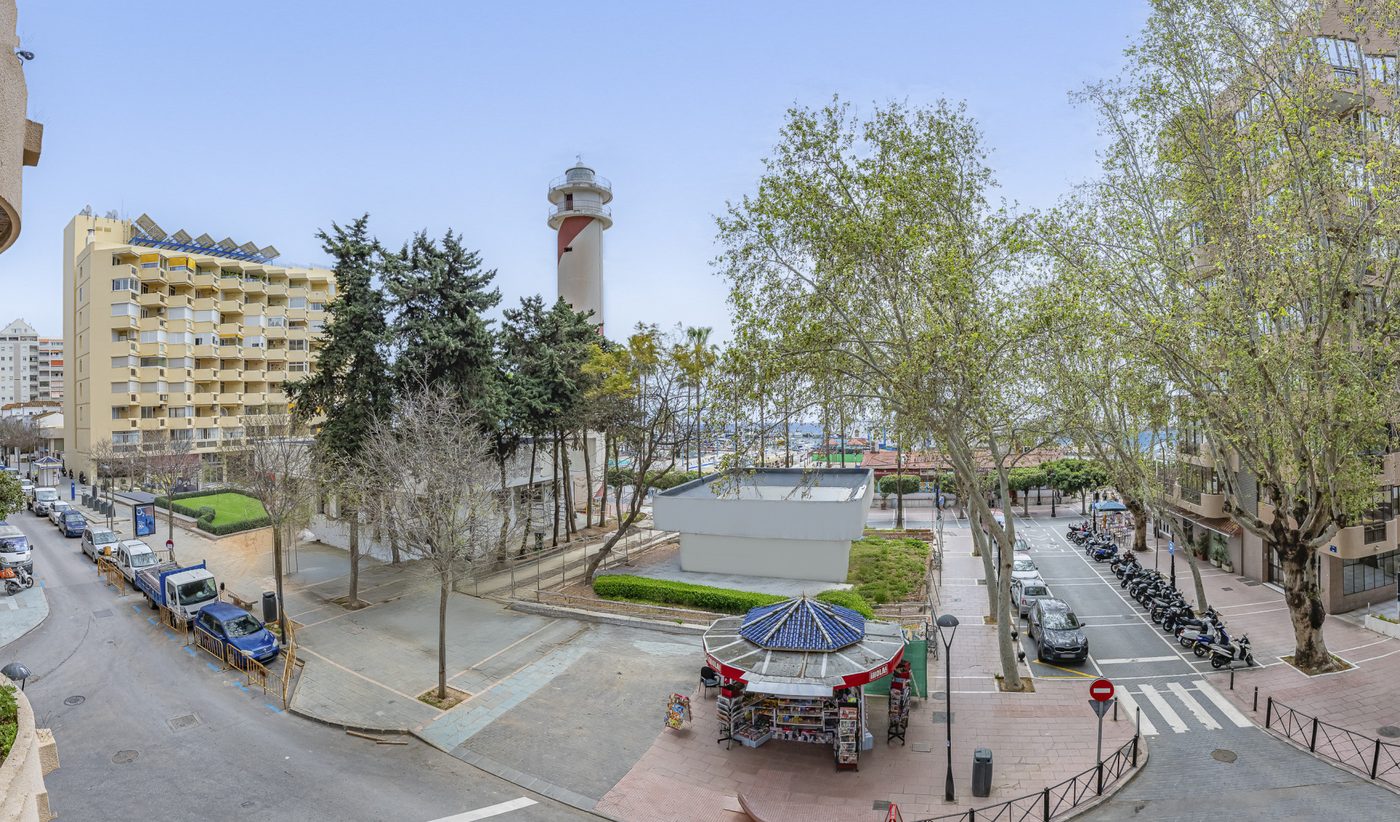 Central Marbella from above, the plane trees and the newspaper kiosk with the lighthouse and the marina behind