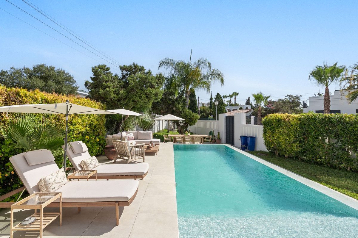 Pool, loungers and hedged garden of a house in Marbesa