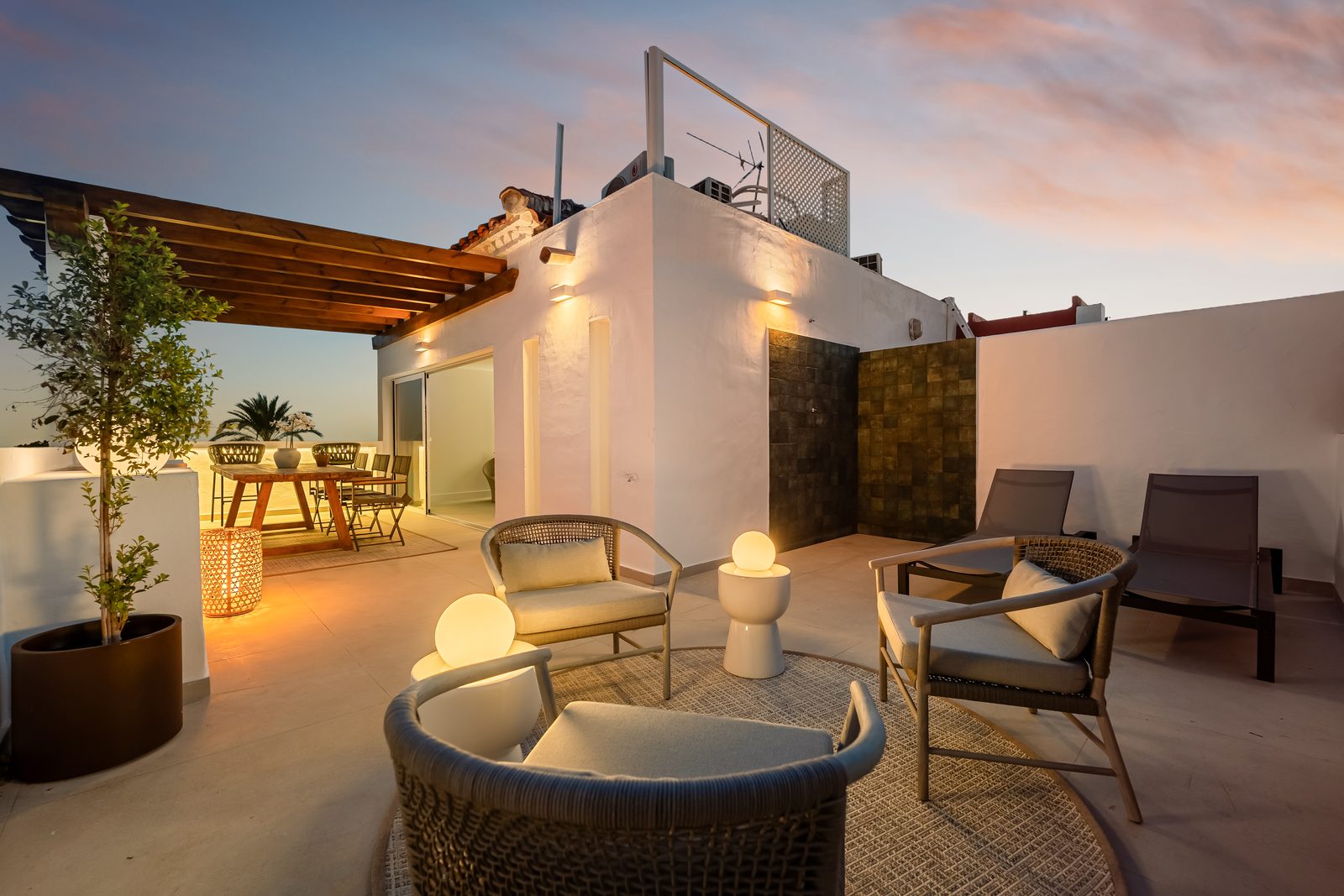 Terrace of a renovated home in Nagüeles, Marbella, looking out over the coast at dusk