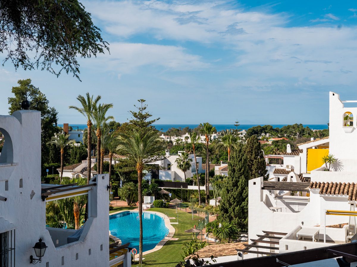 A community pool and gardens in Nueva Andalucía with the valley behind