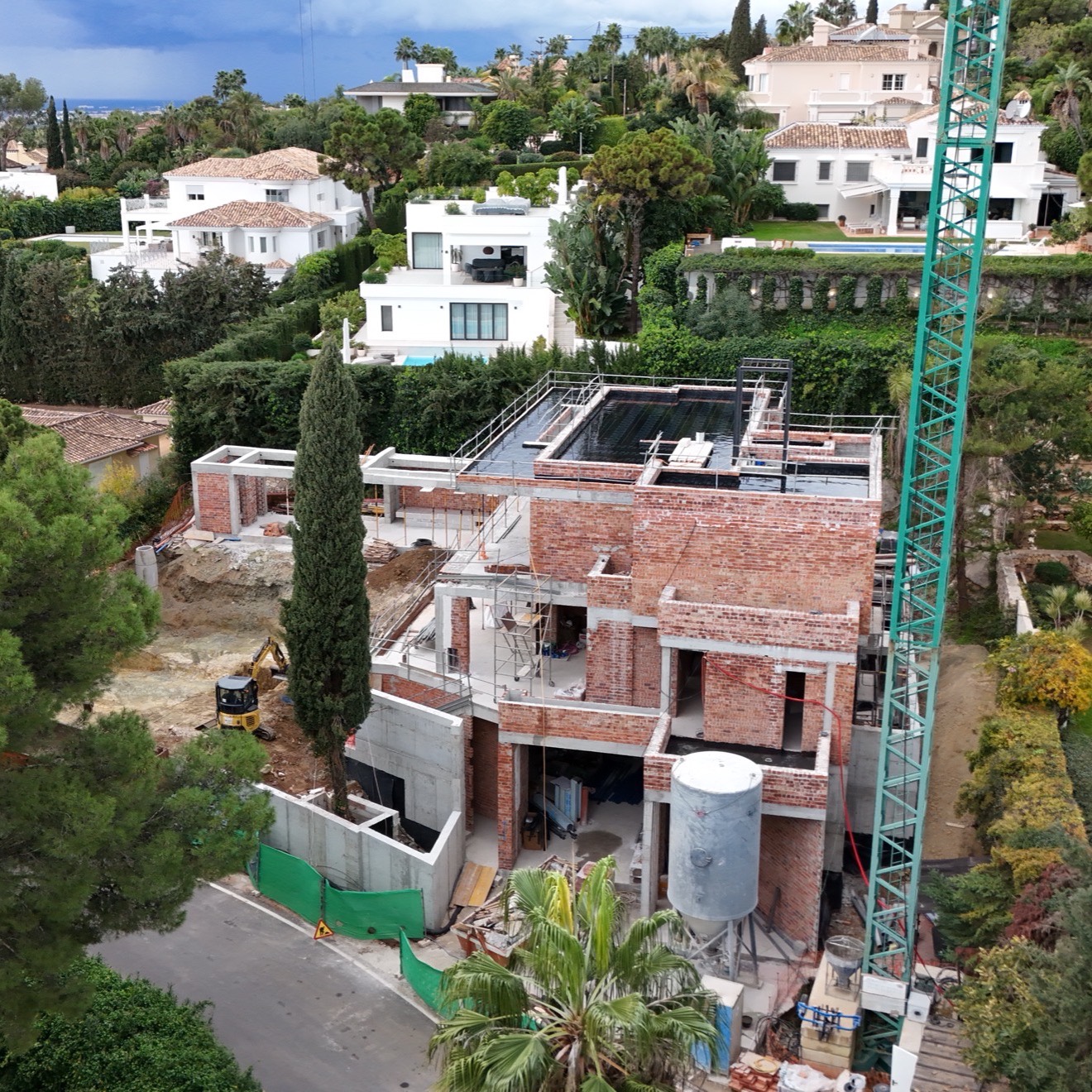 A villa under construction on a hillside plot above the Marbella coast, the stage at which licensing and regularisation under the Marbella PGOM are tested