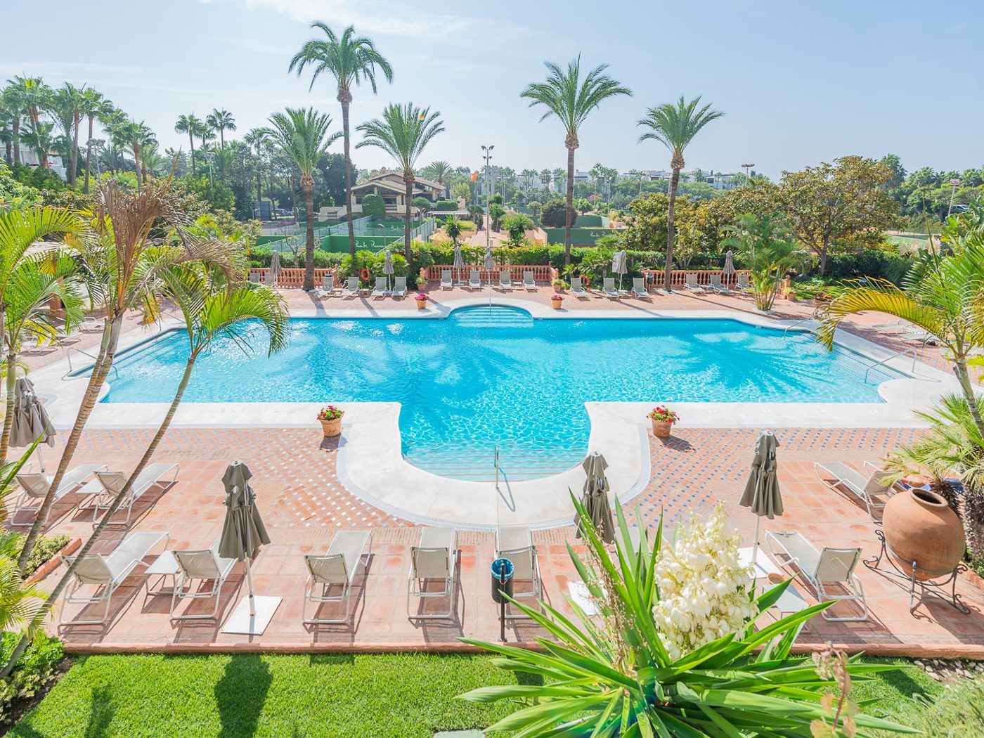 Gardens and a pool between the whitewashed blocks at Puente Romano, Marbella