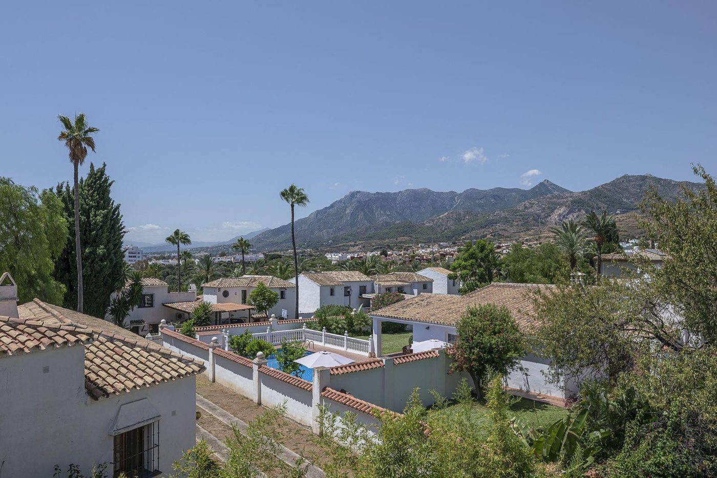 Tiled roofs of houses at Río Real with the Sierra Blanca ridge behind