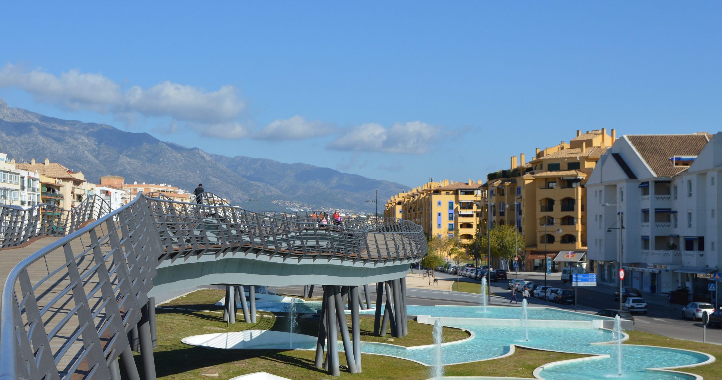 The bulevar of San Pedro de Alcántara from its footbridge, the water gardens and the town below the Sierra Blanca