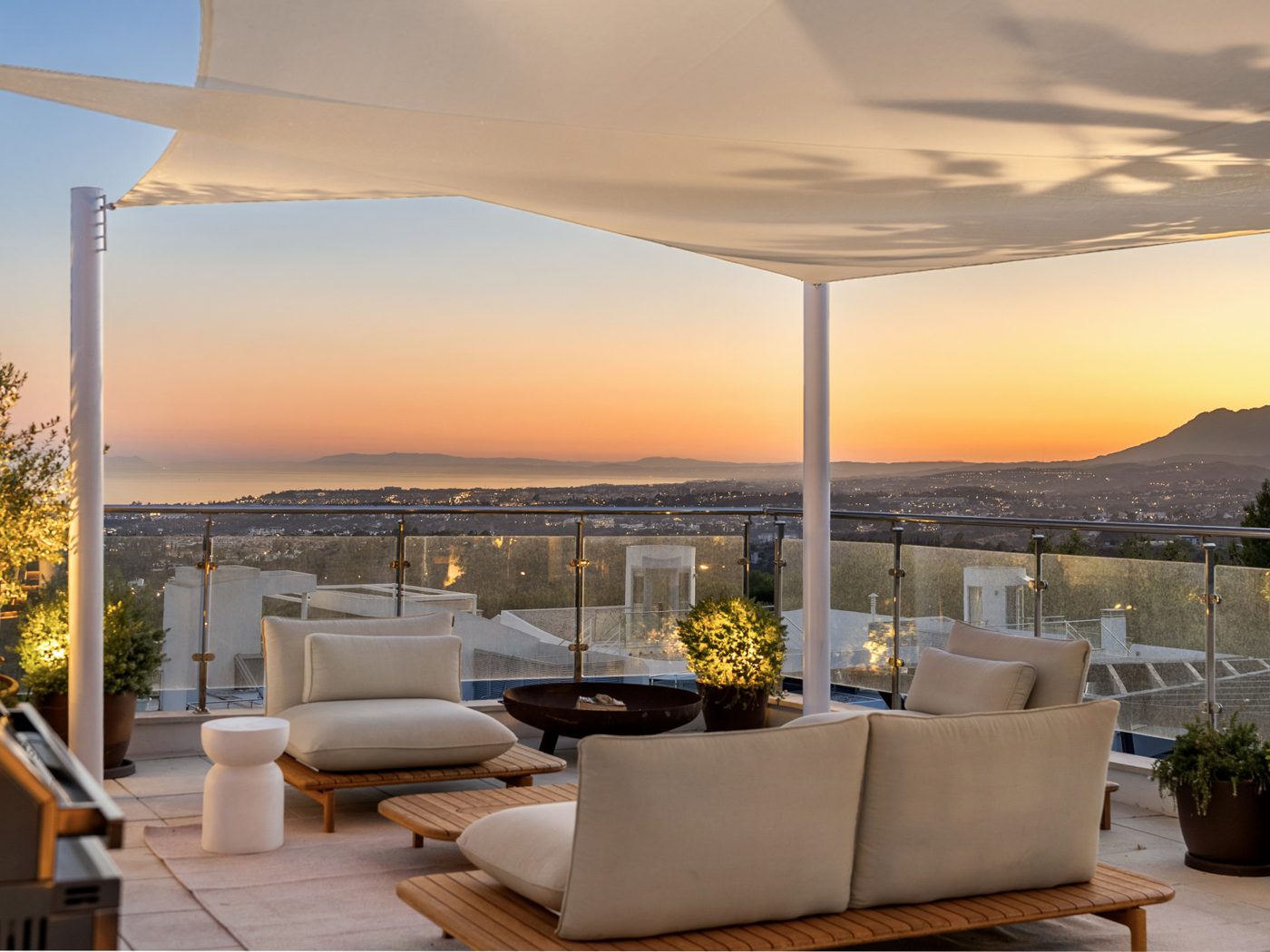 A Sierra Blanca terrace at dusk looking over Marbella to the sea