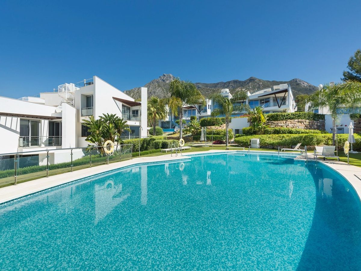 Townhouses around a shared pool in Sierra Blanca with La Concha behind