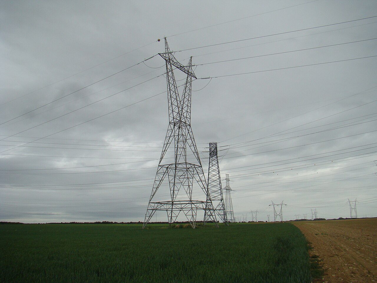 High-voltage transmission pylons carrying electricity across a field in Spain