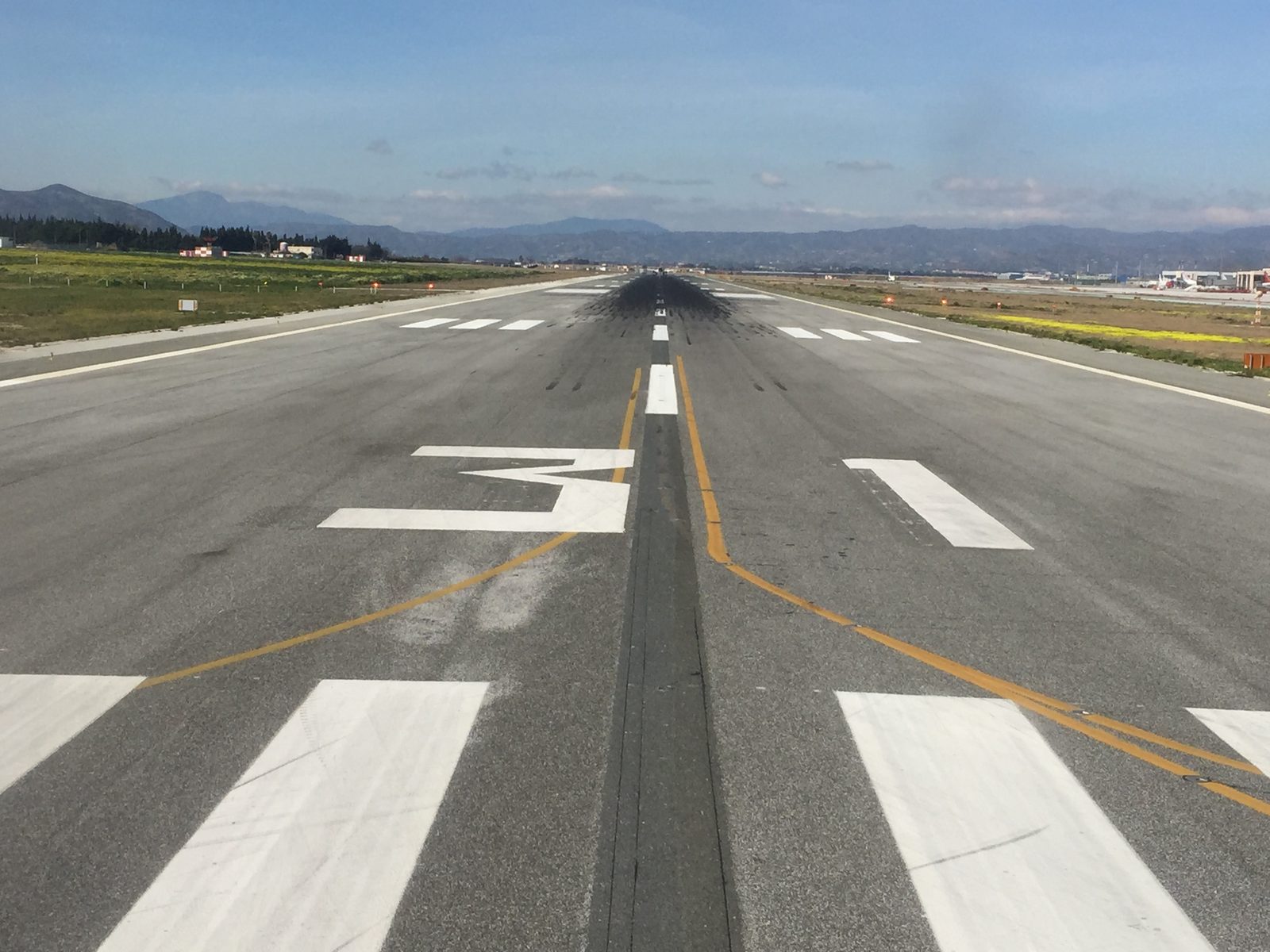 Runway view at Málaga airport with the hills behind Málaga in the distance
