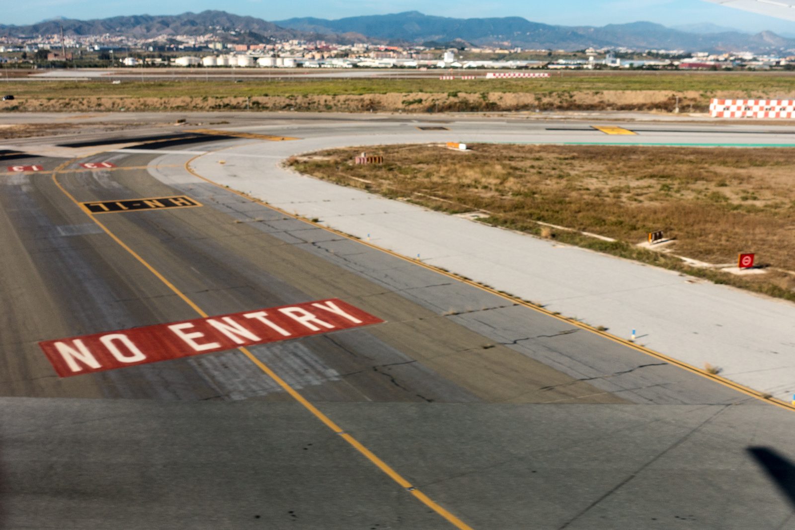 Taxiway and runway at Málaga airport with mountains behind
