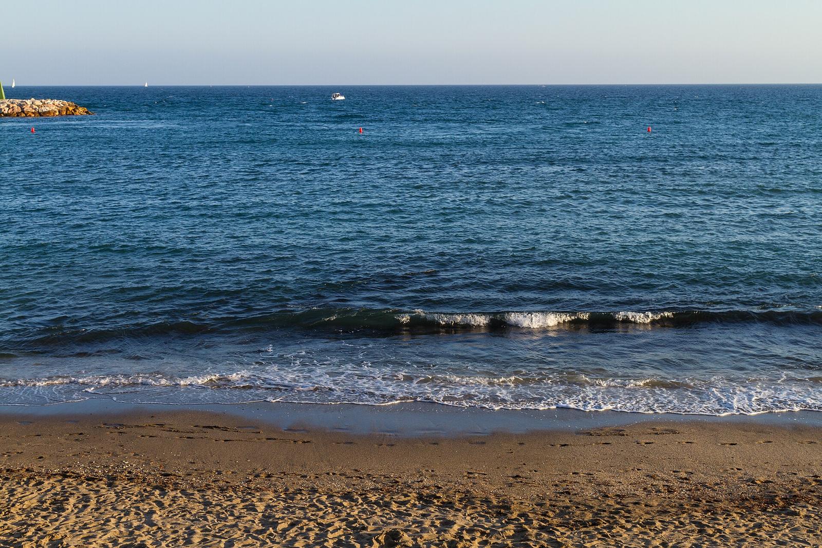 Quiet stretch of Marbella coastline with mountains in the distance